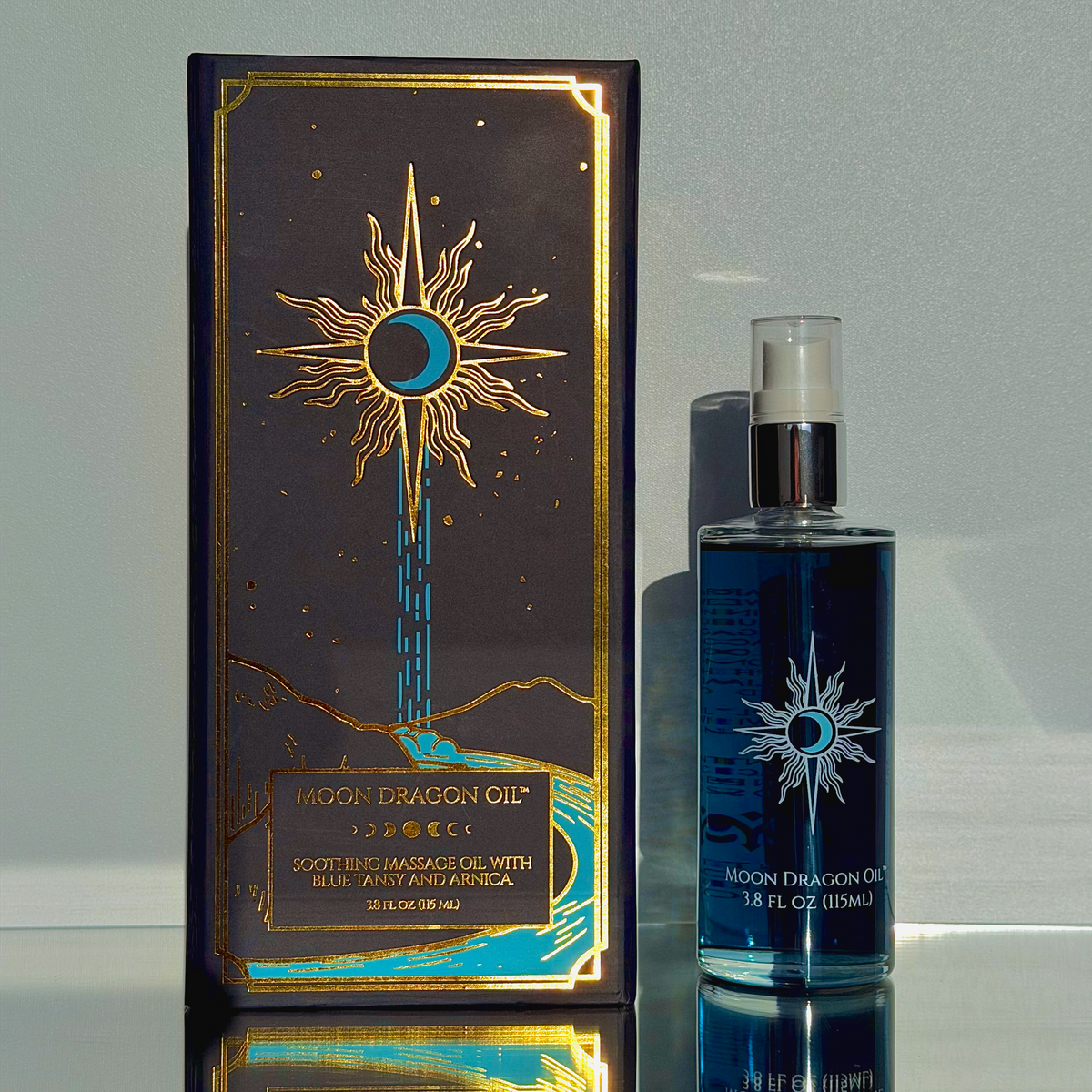 Moon Dragon Oil packaging and bottle on a reflective surface with a light gray background