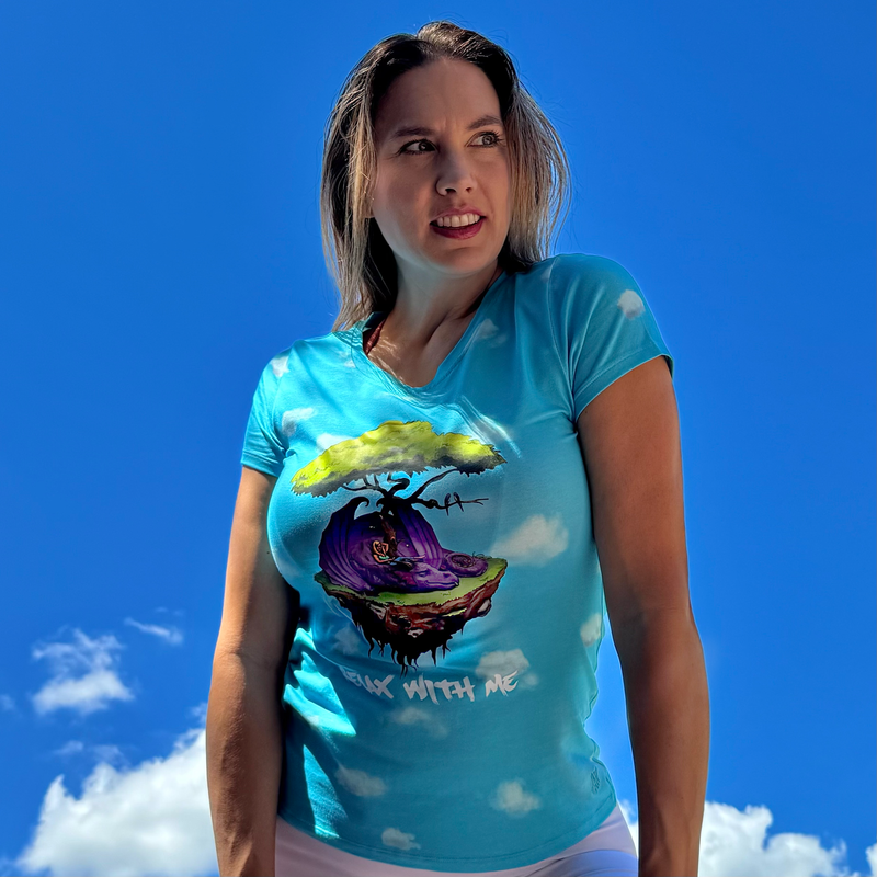Woman wearing a blue t-shirt with a colorful graphic design against a blue sky.