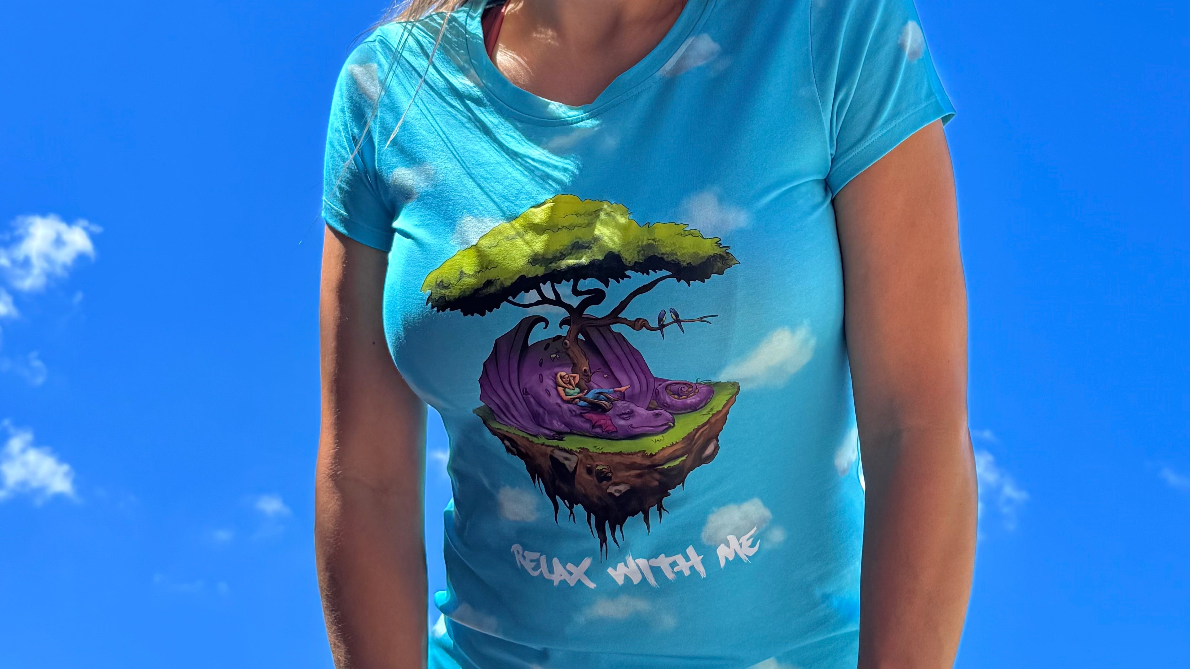 Person wearing a blue t-shirt with a colorful graphic design against a blue sky.