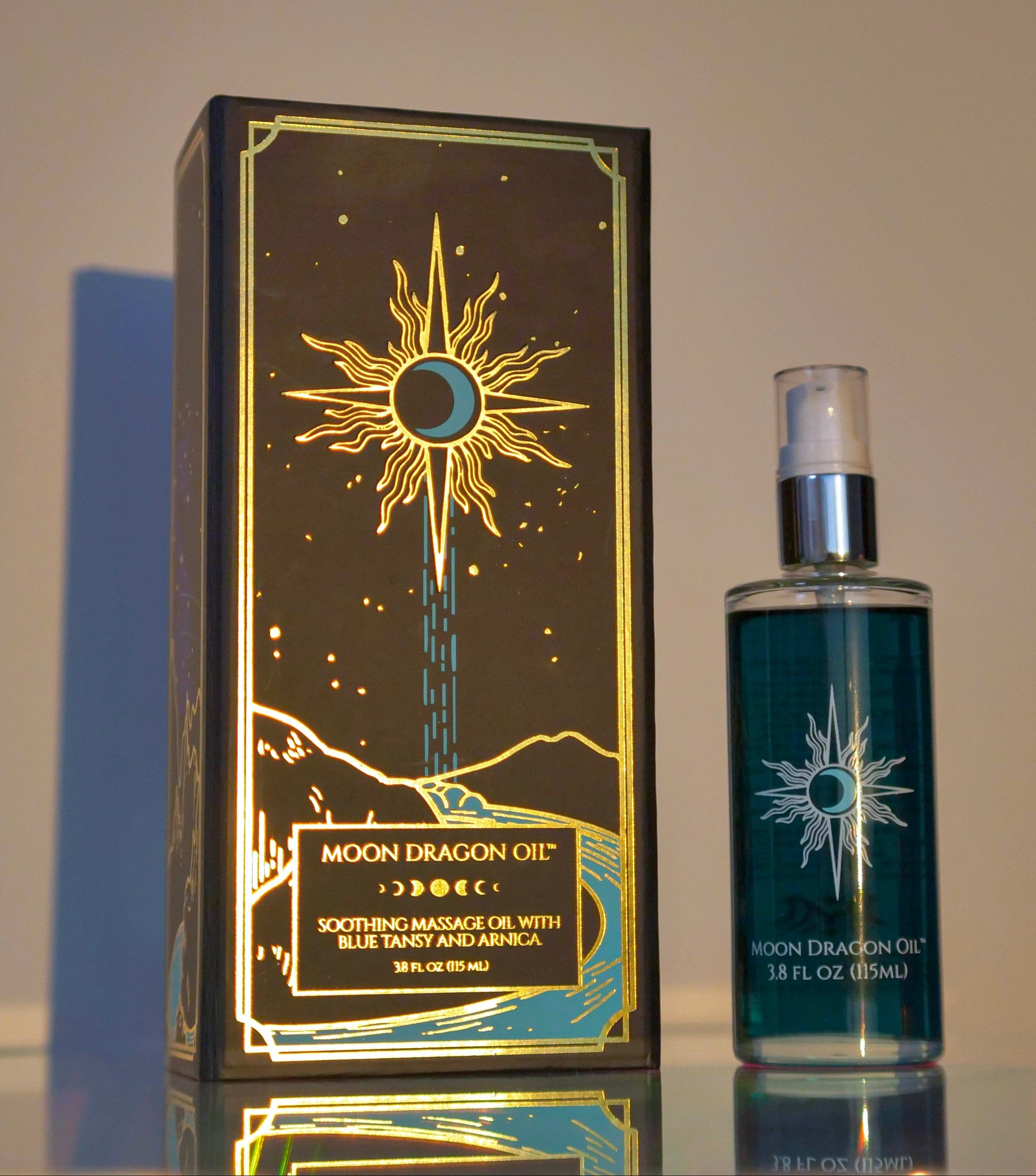 Moon Dragon Oil packaging and bottle on a reflective surface with a neutral background